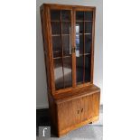 E. Gomme - An oak combination bookcase cabinet, the upper section with bar glazed double doors above