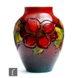 William Moorcroft - A small Flambe vase of swollen form decorated in the Clematis pattern, impressed