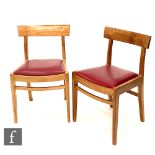 Gordon Russell Furniture - A set of four walnut dining chairs with rail backs above red vinyl drop