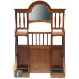In the manner of Liberty & Co - An oak hallstand, the central arched mirror flanked by pierced laths