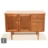 In the manner of Meredew Furniture - An oak sideboard, fitted with a double door cupboard flanked by
