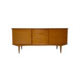 Alfred Cox Furniture - A walnut veneered sideboard by Alfred Cox, fitted with a central bank of