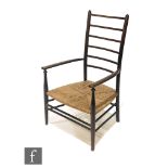 Attributed to Liberty & Co - A stained beech ladderback fireside armchair with woven grass seat