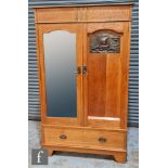 Unknown - An oak wardrobe, the cornice pediment above double doors with a mirror
