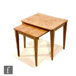 Gordon Russell Furniture - A nest of two walnut occasional tables raised to tapered legs, bearing