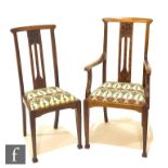 In the manner of Liberty & Co - A set of six oak dining chairs, the pierced backs with carved