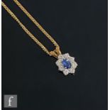 An 18ct hallmarked oval sapphire and diamond pendant, central claw set sapphire, length 6.5mm,