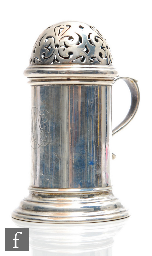 A hallmarked silver castor of plain cylindrical form, with pierced domed top and plain scroll side