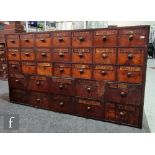 A 19th Century mahogany and pine chemist bank of thirty one drawers in two sizes, turned wood