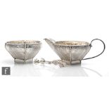 A Middle Eastern silver cream, sugar and tongs, each with leaf decoration above a square plain foot,