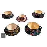 Five assorted 1930s Longwy Art Deco cups and saucers comprising three with a floral pattern over a