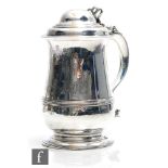 A George II hallmarked silver tankard of baluster form with engraved armorial to plain body below