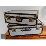 Two later 20th Century aluminium suitcases with riveted black plastic trims, unlabelled and both