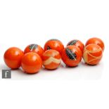 A small collection of nine hand decorated orange display balls, four decorated with stylised black
