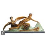 A large Art Deco painted plaster study depicting a female skier chased by a large stylised bird,
