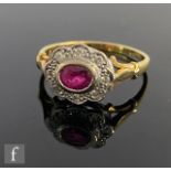 An 18ct ruby and diamond cluster ring, central oval collar set ruby within a eight stone diamond