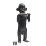 An African Benin style bronze figure, in standing position holding a club, with all over patinated