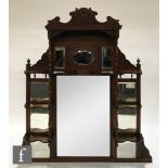 A late 19th Century walnut overmantel mirror, the central rectangular mirror panel flanked by nine