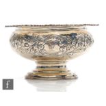 A hallmarked silver pedestal bowl decorated with embossed floral details below flower head and