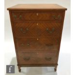 An early 20th Century satin walnut veneered chest of four graduated drawers, the cross-banded top