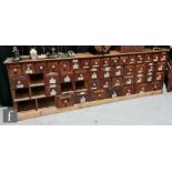 A 19th Century bank of forty nine chemist drawers, various sizes, glass handles, names missing,