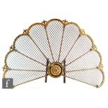 An Edwardian pierced brass fan shaped spark guard with iron supports, width 68cm.