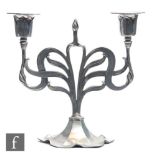 An Art Nouveau early 20th Century Orivit polished pewter candelabra, the flowerhead shaped base