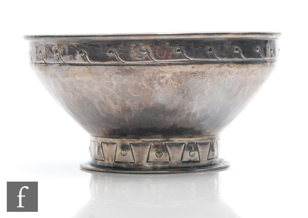 A hallmarked silver Arts and Crafts small pedestal bowl with planished decoration above stylised