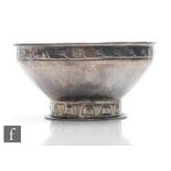 A hallmarked silver Arts and Crafts small pedestal bowl with planished decoration above stylised