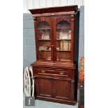 A Victorian mahogany secretaire bookcase enclosed by a pair of glazed doors below a fluted