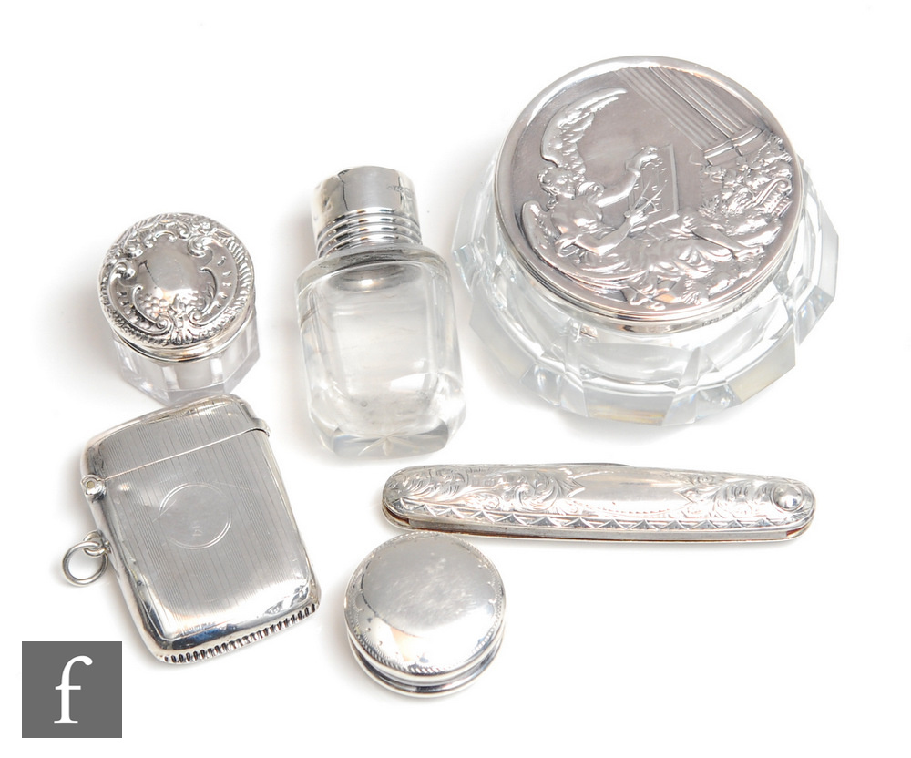 Six early 20th Century items of hallmarked silver three small dressing table jars, a vesta case, a