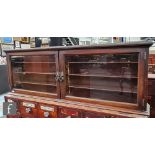An early 20th Century mahogany wall cabinet, the wooden shelf interior enclosed by a pair of