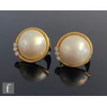 A pair of 18ct hallmarked mabe pearl and diamond stud earrings, pearls within a collar setting