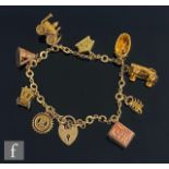 A mid 20th Century 9ct fancy link chain with nine assorted 9ct charms attached, total weight 31g,