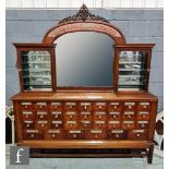 A 19th Century and later constructed chemist's thirty five drawer cabinet below a central mirror