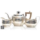 A hallmarked silver boat shaped three piece tea set of plain form each terminating in reeded
