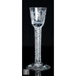 An 18th Century gin glass, circa 1750, the round funnel bowl engraved with a floral spray with