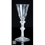 An 18th Century drinking glass, circa 1750, the round funnel bowl above an double annulated