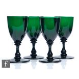A group of four 19th Century Bristol green drinking glasses with round funnel bowl with basal bladed