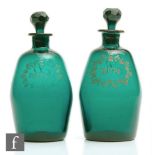 A pair of late Georgian barrel form green glass decanters circa 1800, the pair decorated with gilded