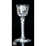 An 18th Century Jacobite drinking glass circa 1765, the ogee bowl engraved with a flowering rose,