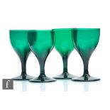 A set of four 19th Century Bristol green drinking glasses with round funnel bowl above a plain stem,