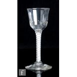 An 18th Century drinking glass, the ogee bowl with basal flutes above a double series opaque twist
