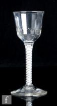 An 18th Century drinking glass, the ogee bowl with basal flutes above a double series opaque twist