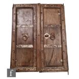 A pair of oak Moorish style oak window shutters each with iron strap details, bosses and ring