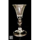 An 18th Century gin glass circa 1740, the bell bowl above a teared baluster steam raised to a folded