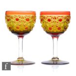 A pair of early 20th Century Stevens & Williams wine glasses, the round funnel bowl cased in ruby