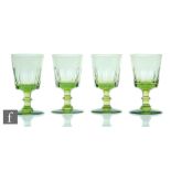 A set of four 19th Century green wine glasses, each with bucket bowl with basal slice cut decoration