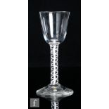 An 18th Century drinking glass circa 1765, a large round funnel bowl above an opaque twist stem with