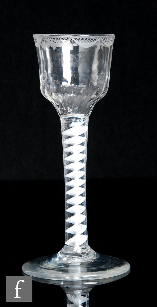 An 18th Century drinking glass, circa 1765, the ogee bowl with rim engraved with criss crossing